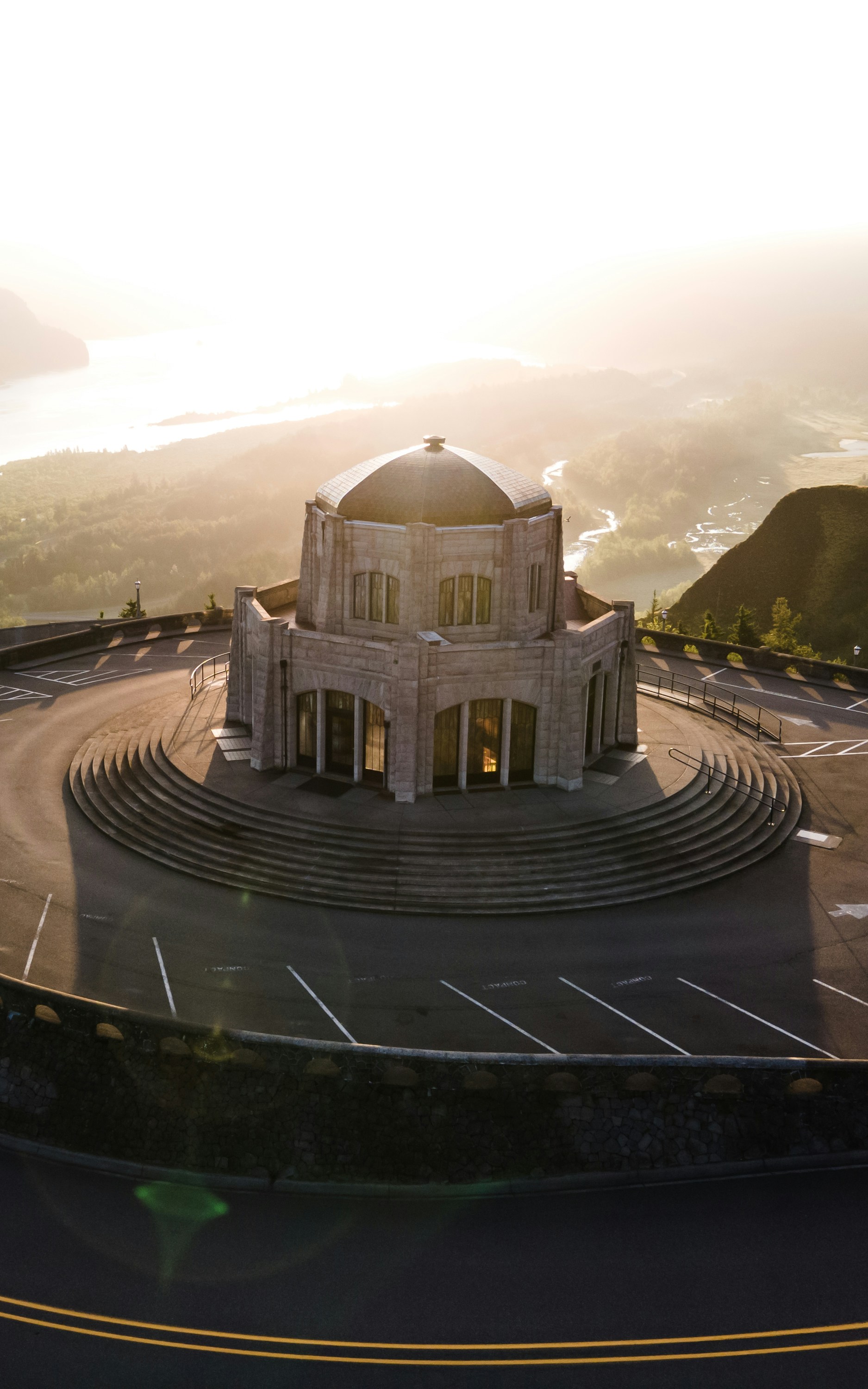 낮에는 녹색 나무 근처의 갈색 콘크리트 건물