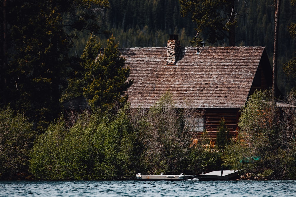 brown brick house near body of water during daytime