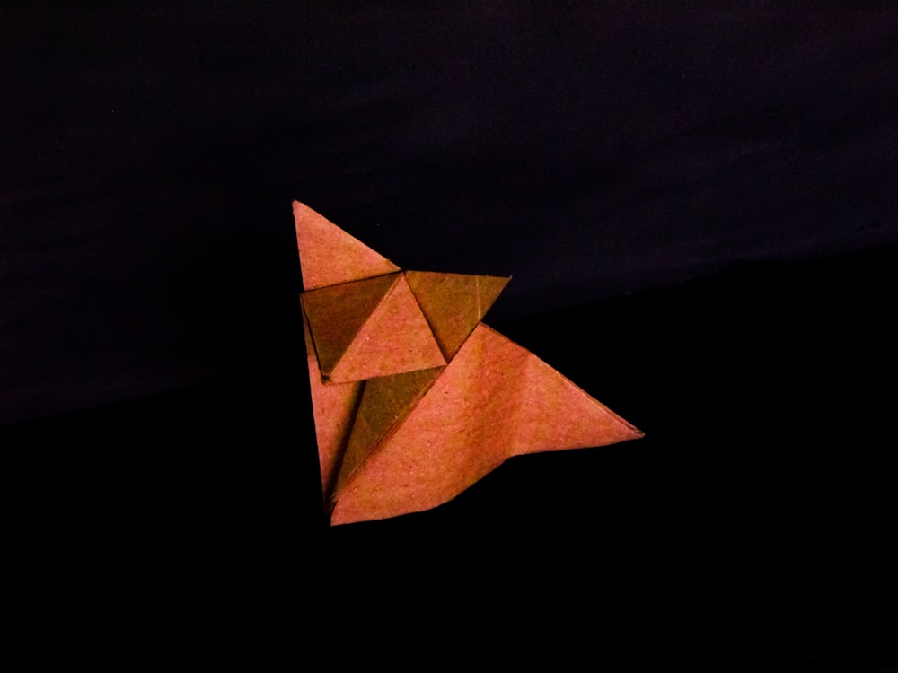 orange paper boat on black background