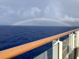 A beautiful glass railing on a balcony overlooking the sea.