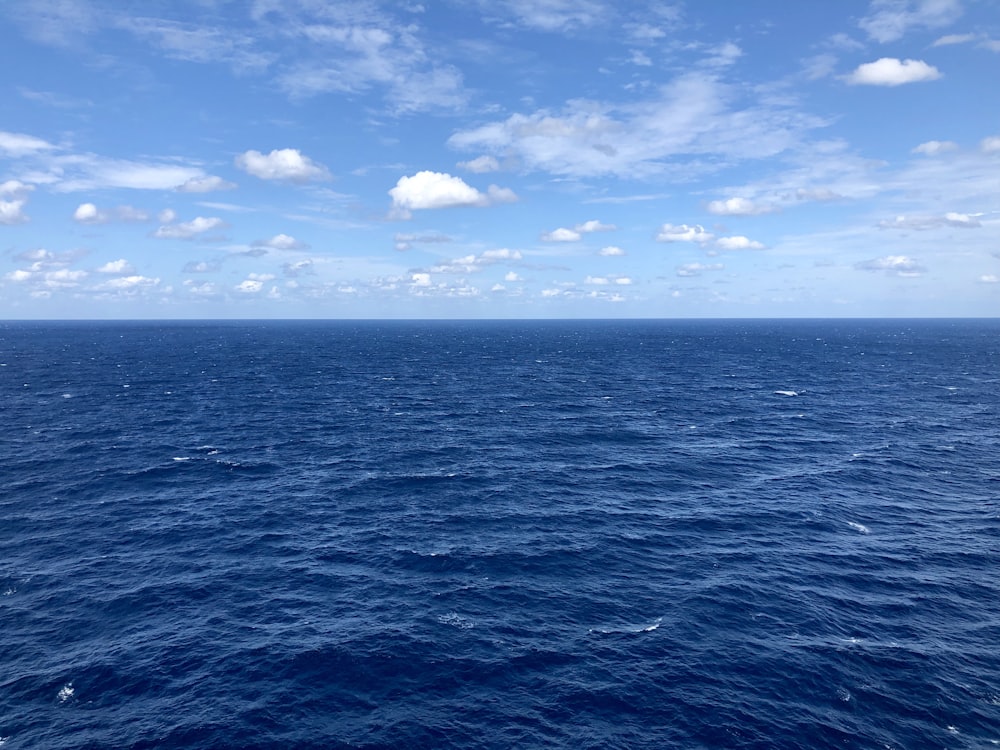 mare blu sotto cielo blu e nuvole bianche durante il giorno