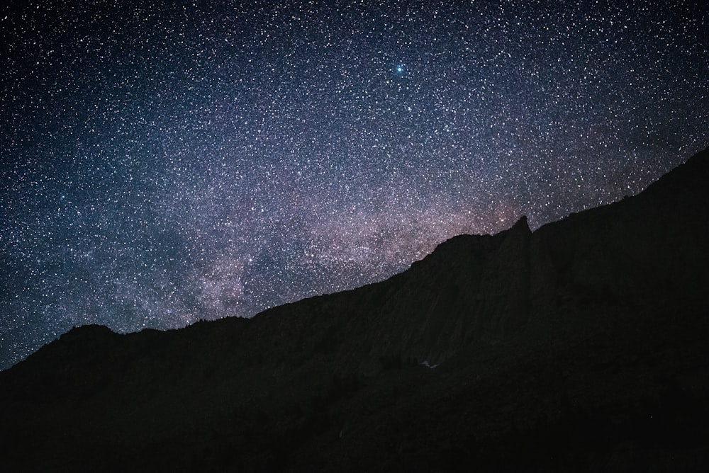 black and white mountain under starry night