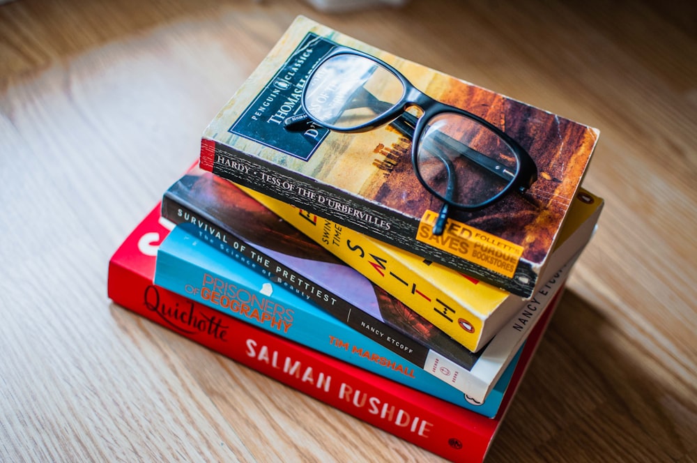 occhiali da vista con montatura nera su libro rosso e giallo