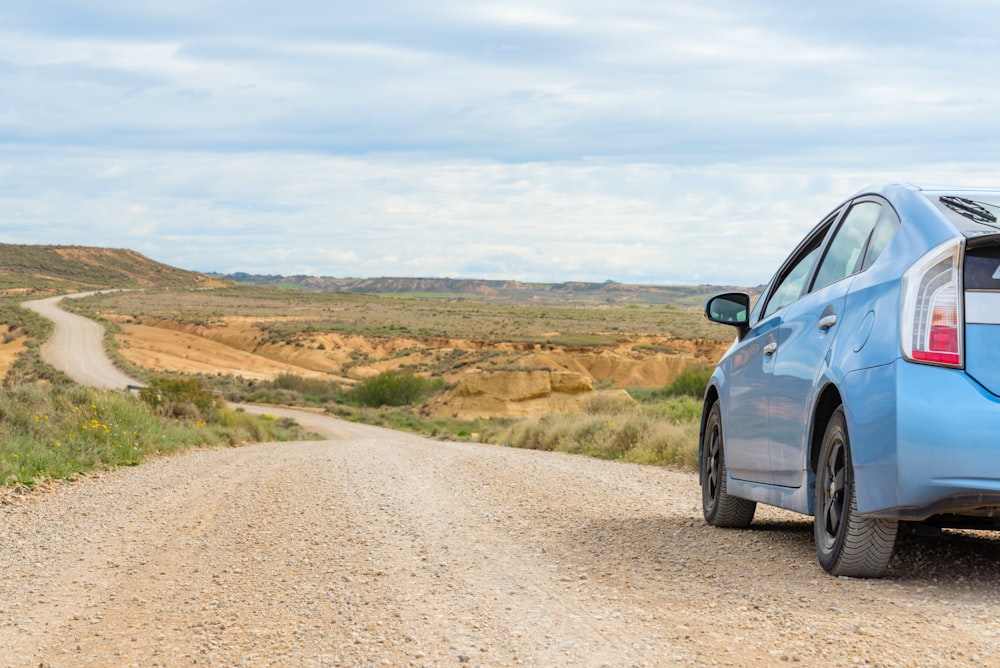 black car on brown dirt road during daytime