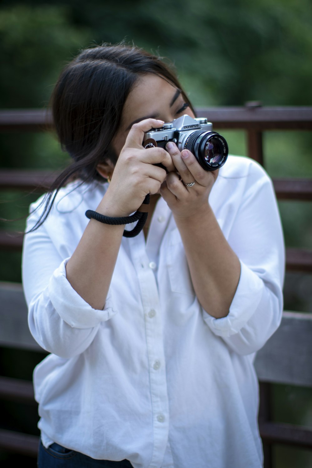 woman in white button up shirt holding black dslr camera