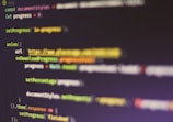 Colorful code is displayed on a computer screen. The code syntax includes syntax highlighting, featuring elements like variables, functions, and URLs. The image is slightly blurred, adding a sense of depth.
