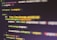 Colorful code is displayed on a computer screen. The code syntax includes syntax highlighting, featuring elements like variables, functions, and URLs. The image is slightly blurred, adding a sense of depth.