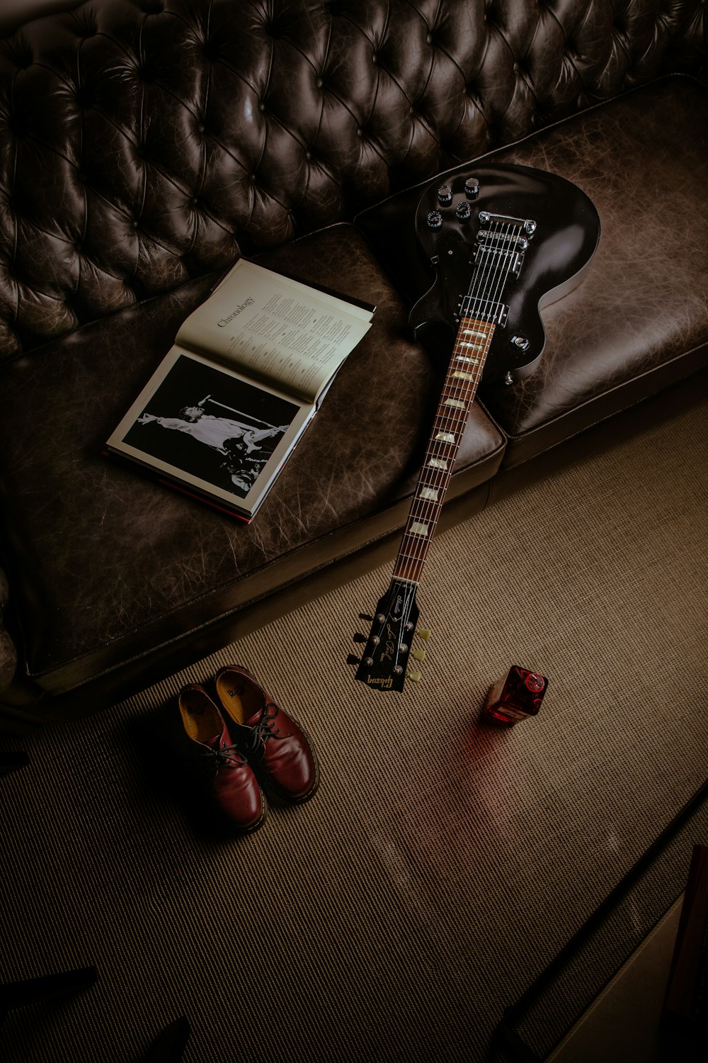 black and white stratocaster electric guitar beside black and white book