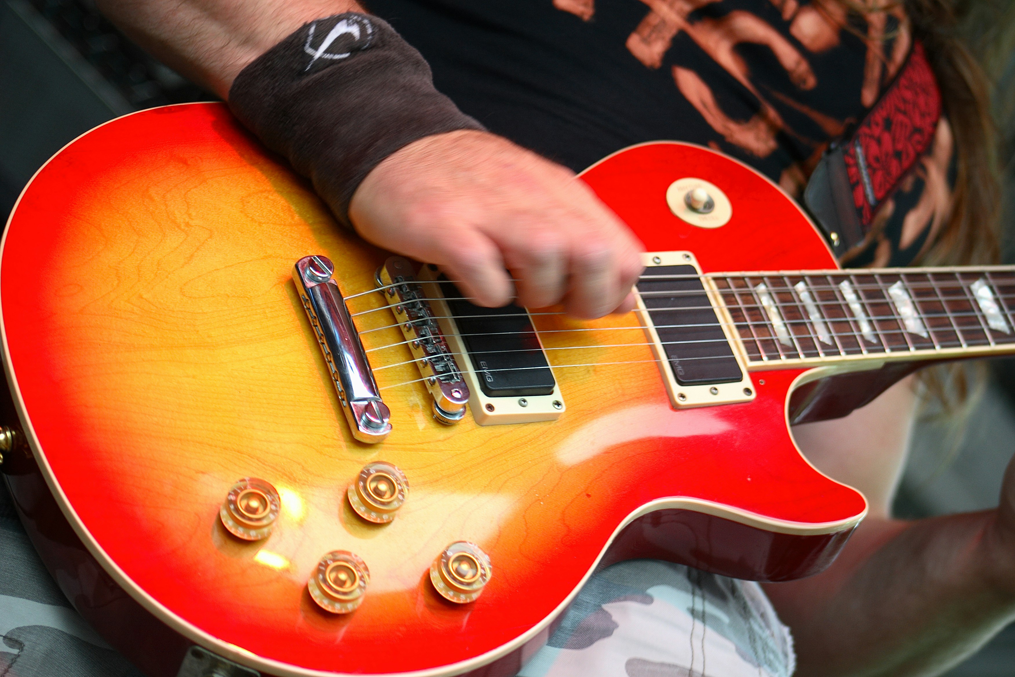 person playing red and white electric guitar