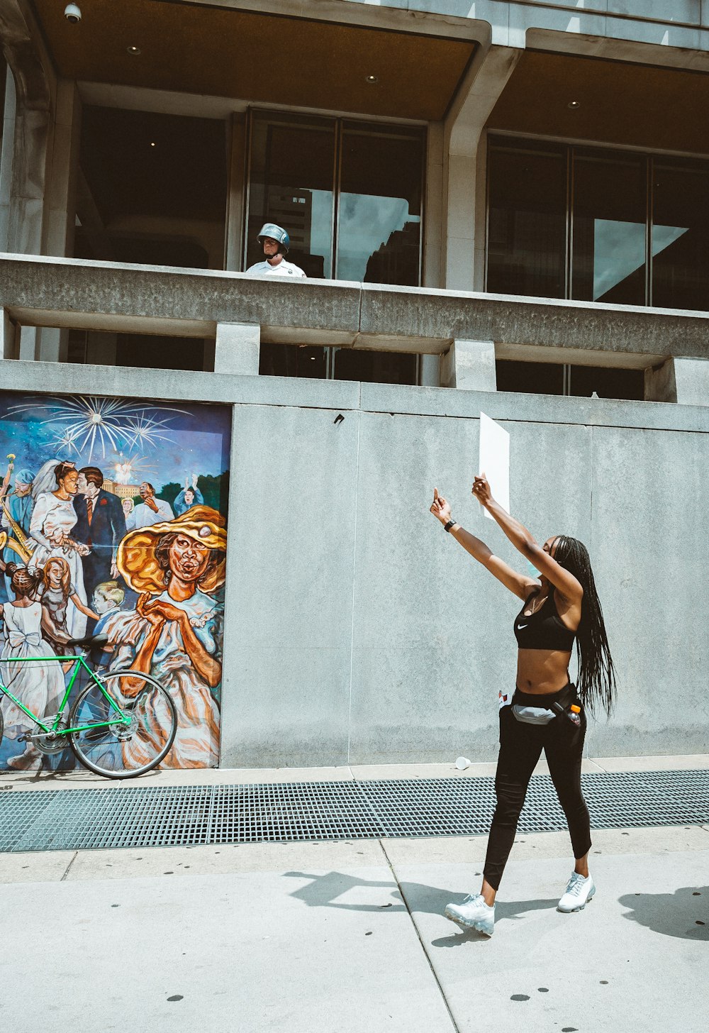 Femme en débardeur noir et short noir debout sur un sol en béton gris pendant la journée