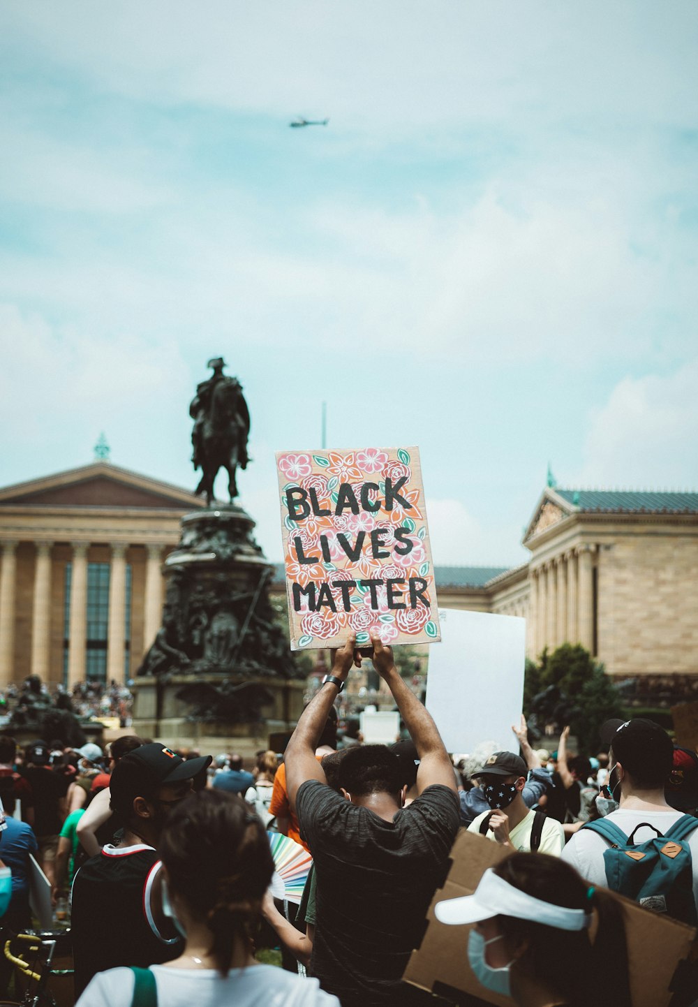 Menschen, die tagsüber ein weißes und schwarz bedrucktes Banner halten