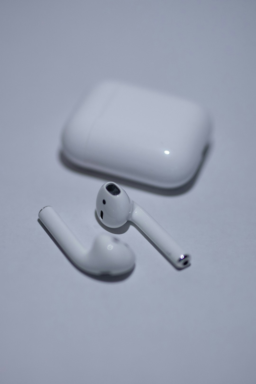 white apple airpods on white surface