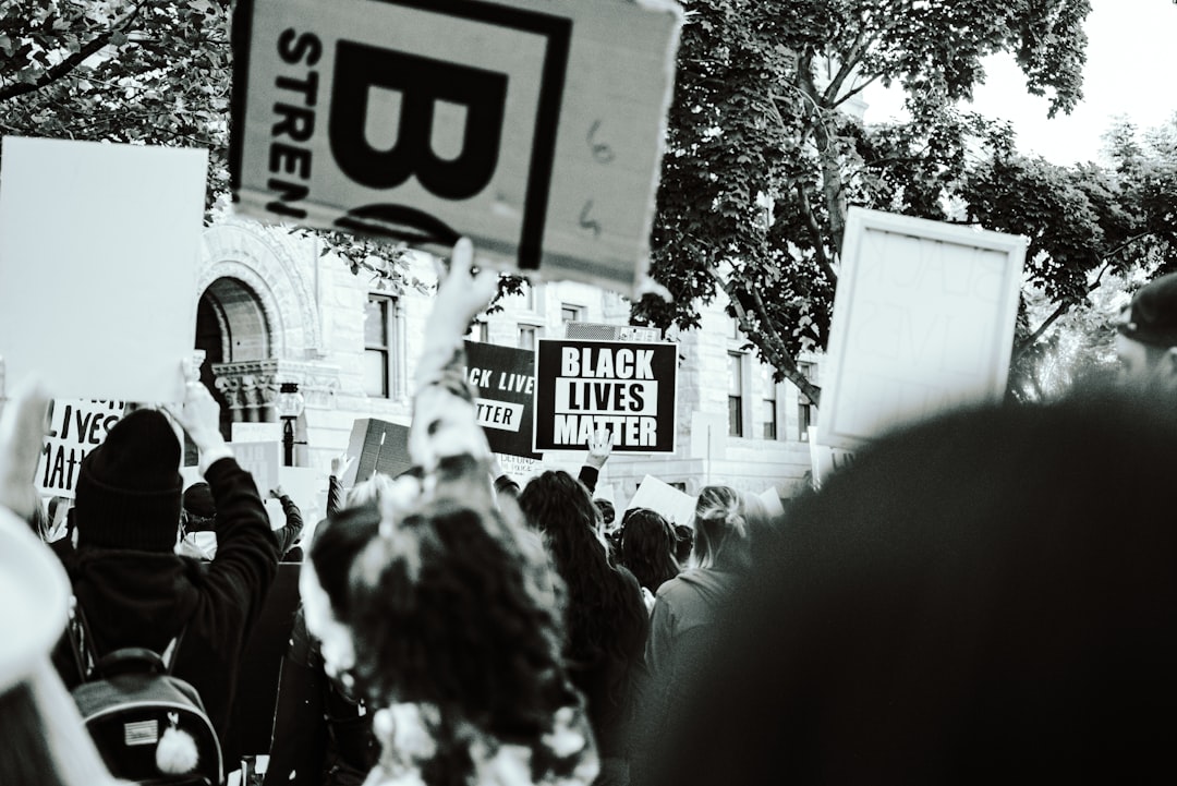 grayscale photo of people holding stop sign