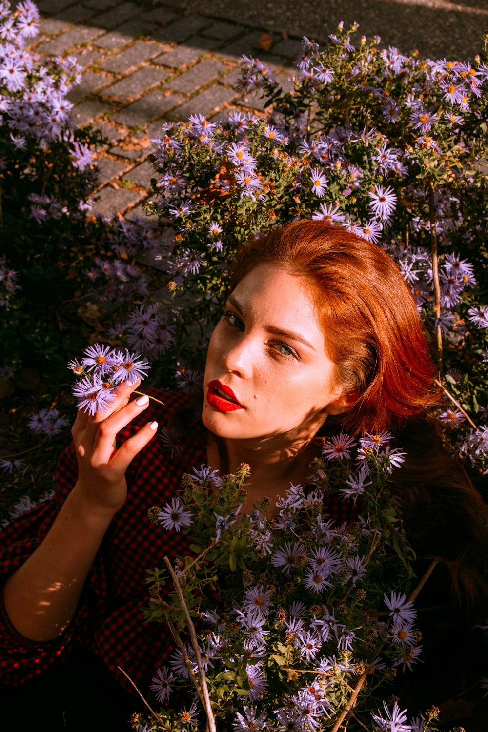 woman in black and white polka dot shirt holding white flowers