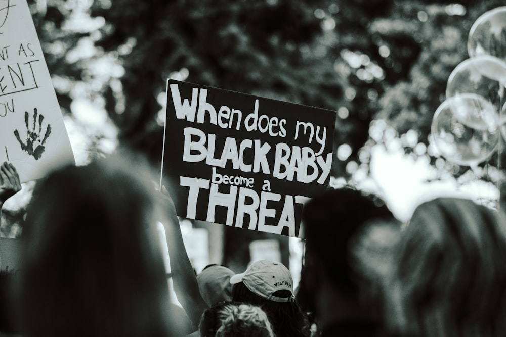 a group of people holding up signs and balloons