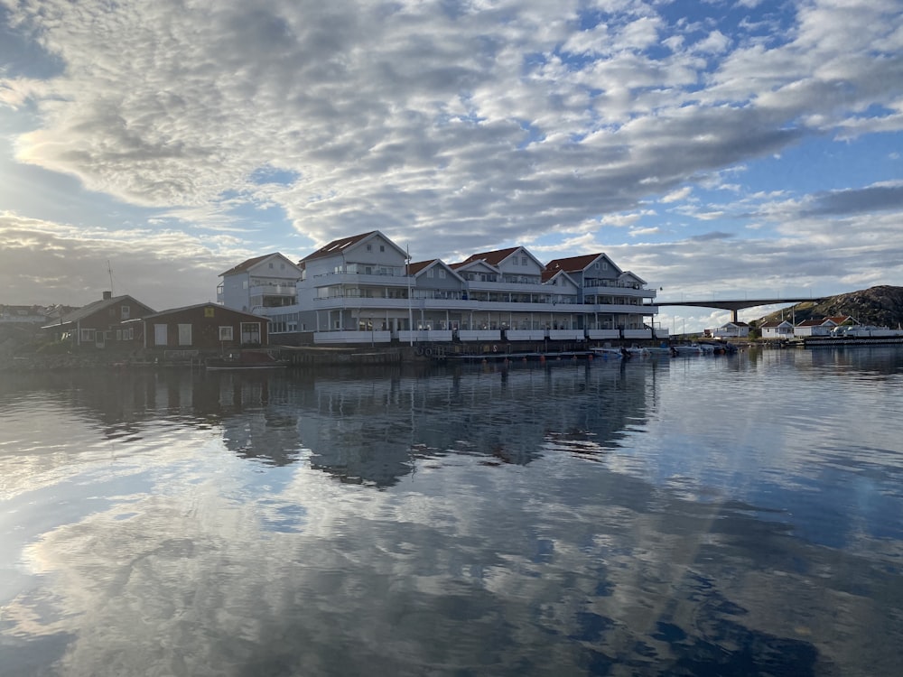 brown and white concrete building beside body of water under cloudy sky during daytime