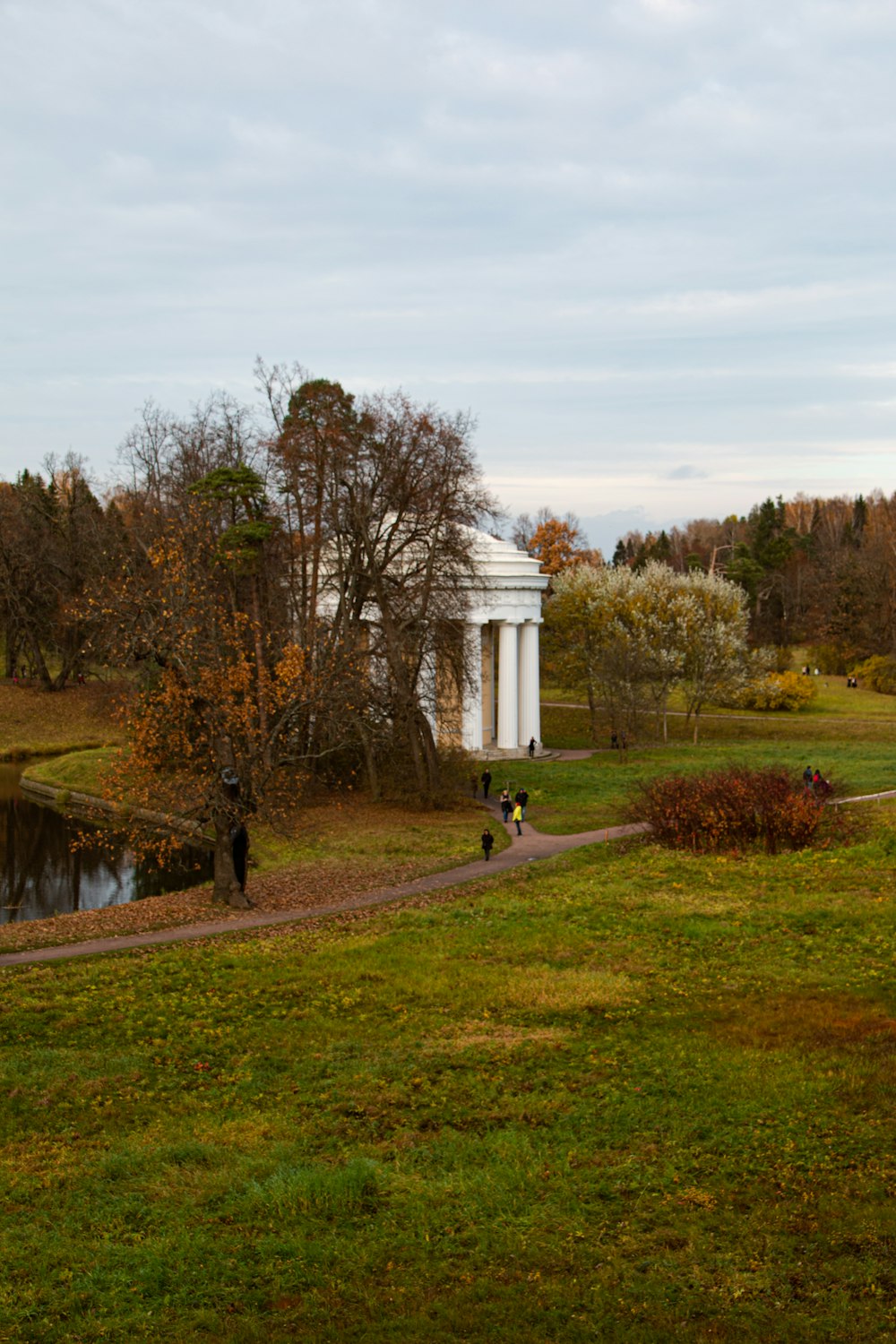 white concrete building near green grass field and trees during daytime