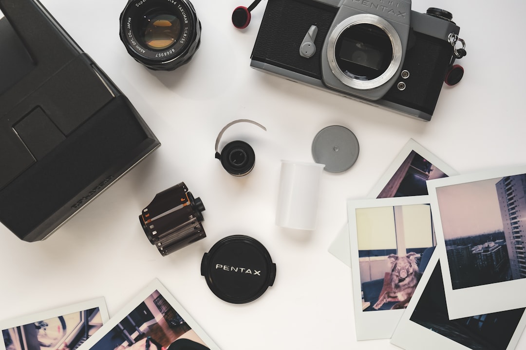 black and silver canon camera lens and black camera lens on white table