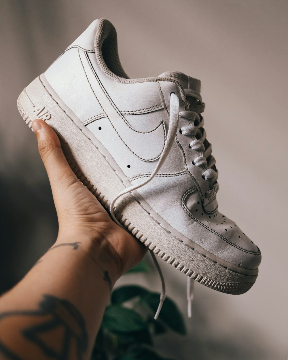 person holding white nike air force 1