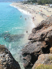 Bright sunny beach in Cape Town with turquoise waters and mountains in the background.