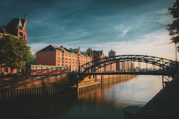 Brown and white concrete building near bridge under cloudy sky during daytime — Hamburg, Germany