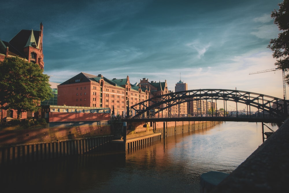 brown and white concrete building near bridge under cloudy sky during daytime