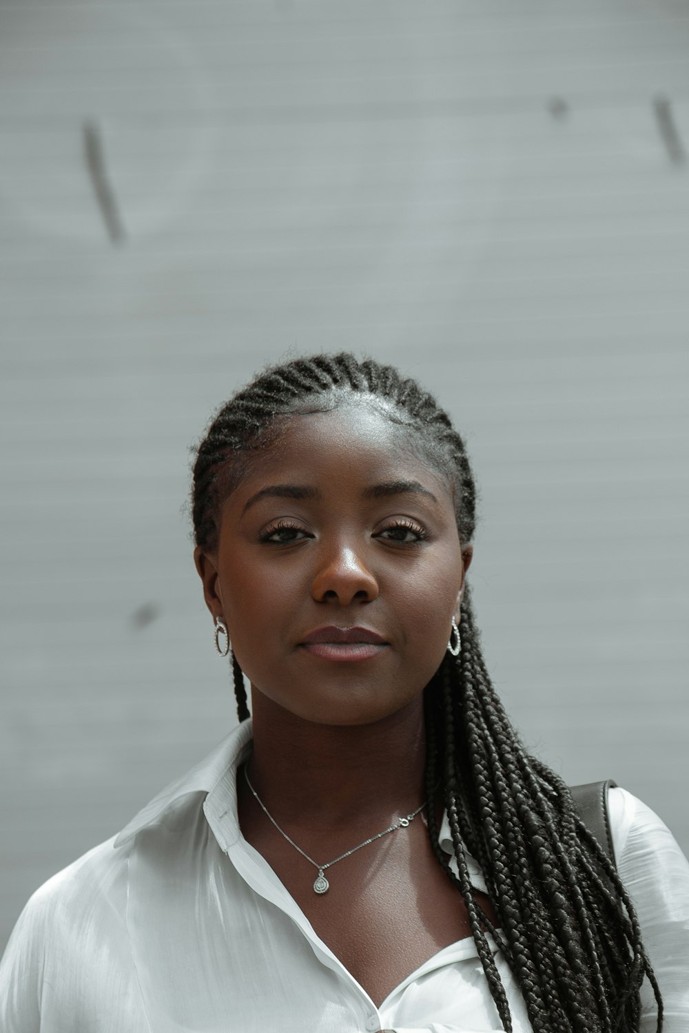 Femme en chemise à col blanc portant un collier en argent