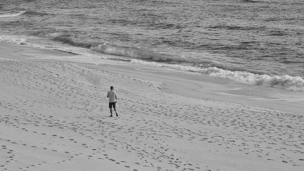 man in black jacket walking on beach during daytime