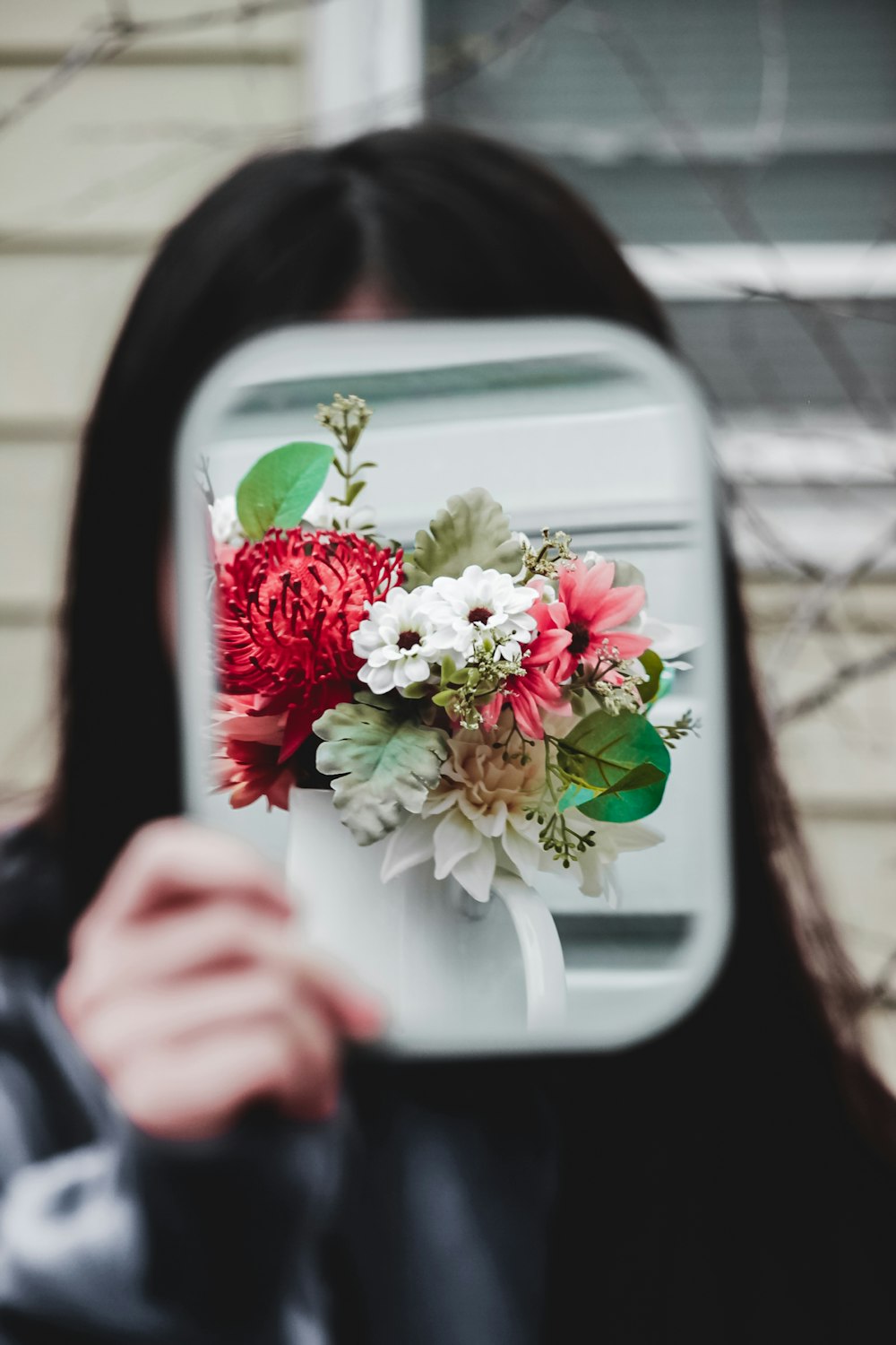 person holding white and red flower bouquet