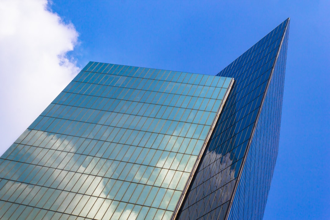 blue and white glass walled building under blue sky during daytime