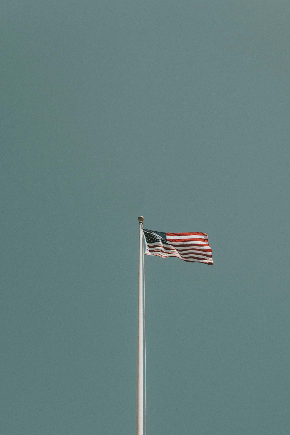 미국 낮 동안 푸른 하늘 아래 기둥에 깃발