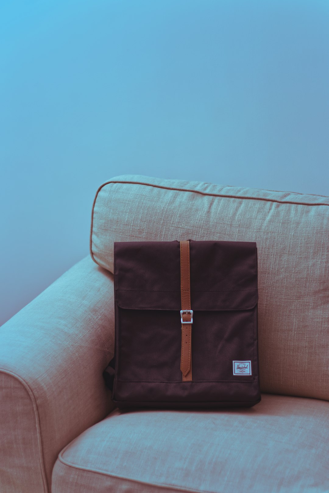 brown leather sling bag on white couch