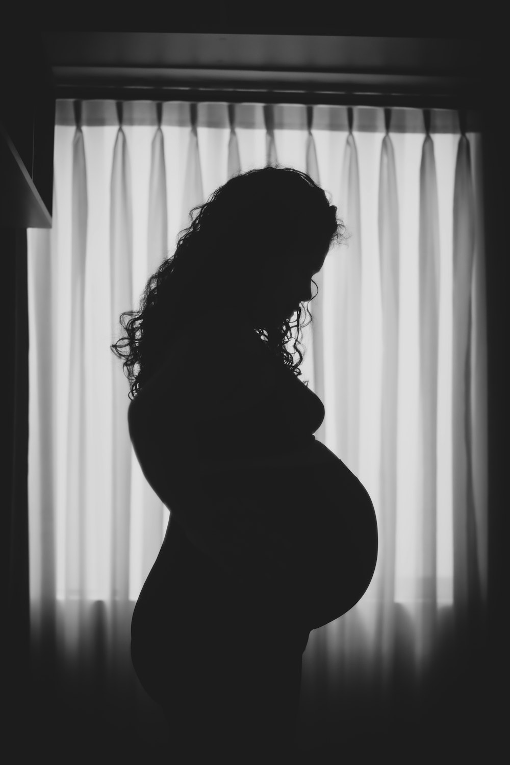 Photo en niveaux de gris d’une femme en manteau noir