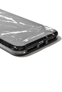 A leather phone cover with a personalized laser engraving of initials.