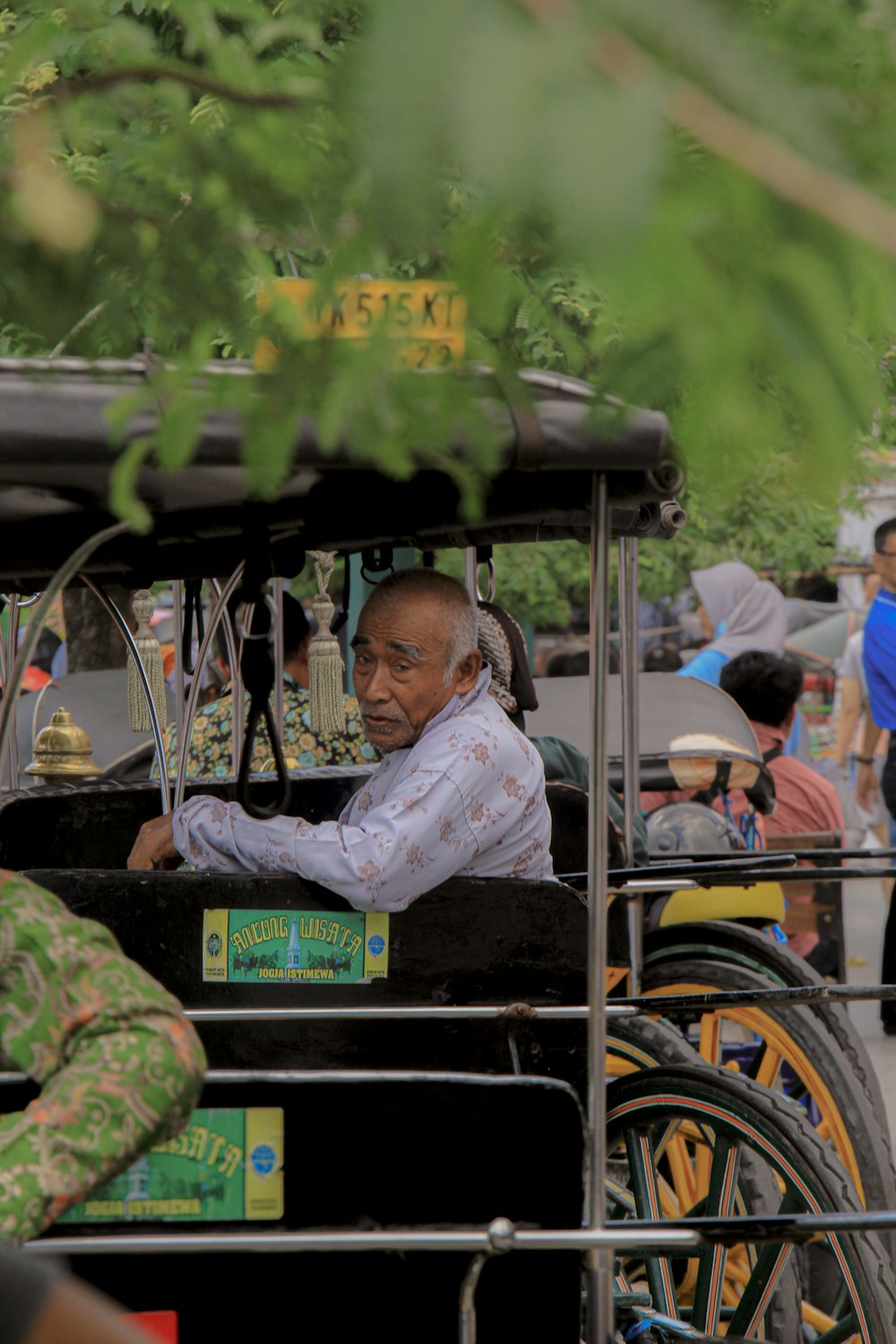 man in white dress shirt sitting on black and yellow auto rickshaw during daytime