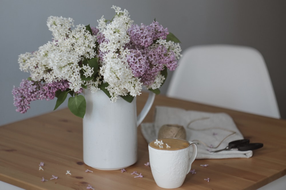 white and purple flowers in white ceramic vase