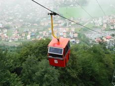 red cable car over city buildings during daytime