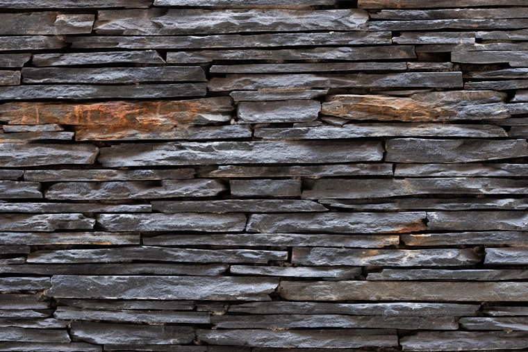 A dark slate stacked stone cladding wall.