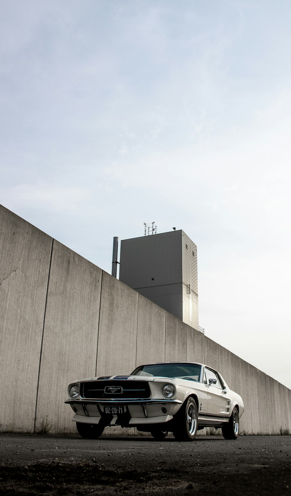 black and white car parked beside brown wall