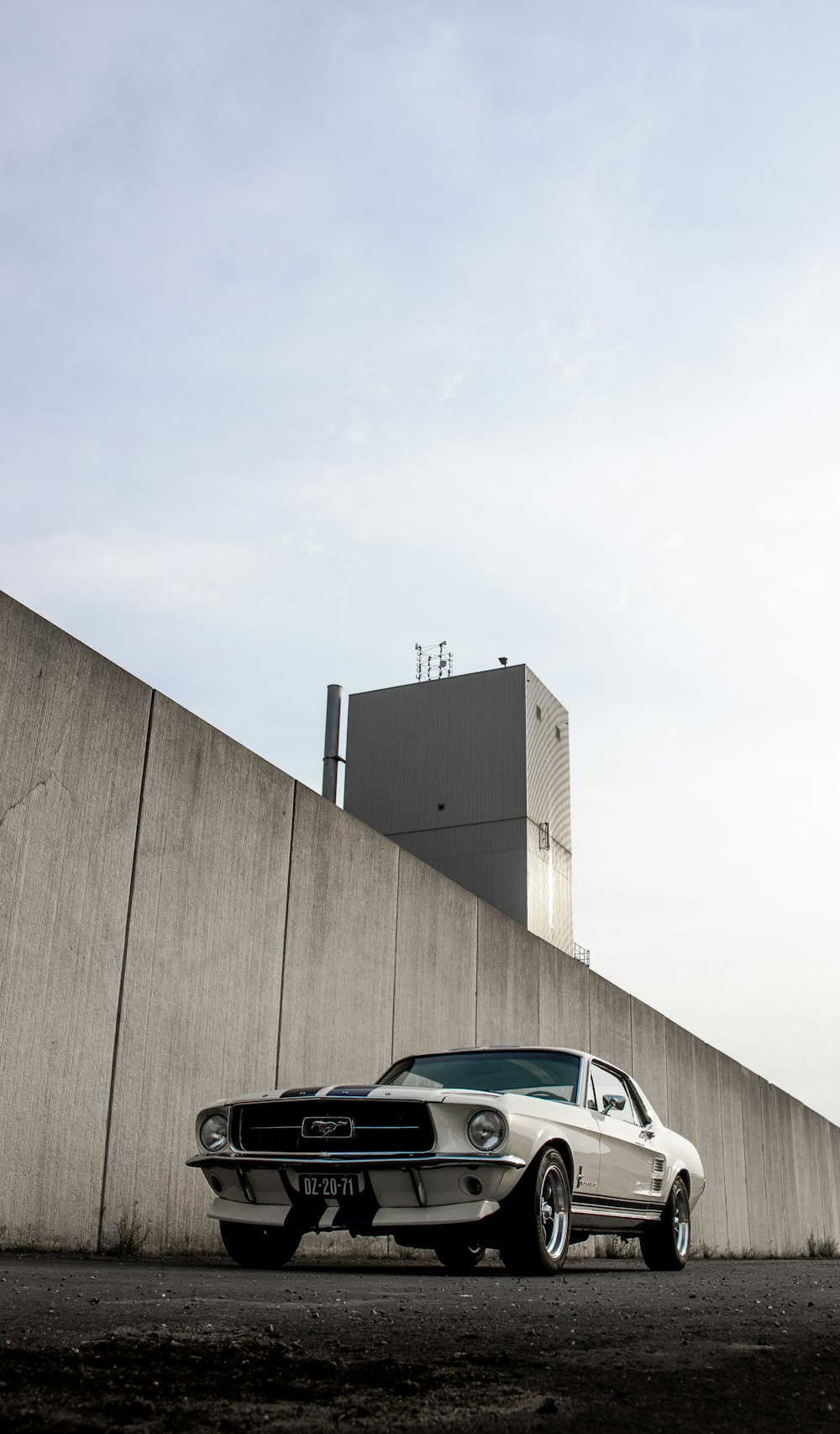 carro preto e branco estacionado ao lado da parede marrom