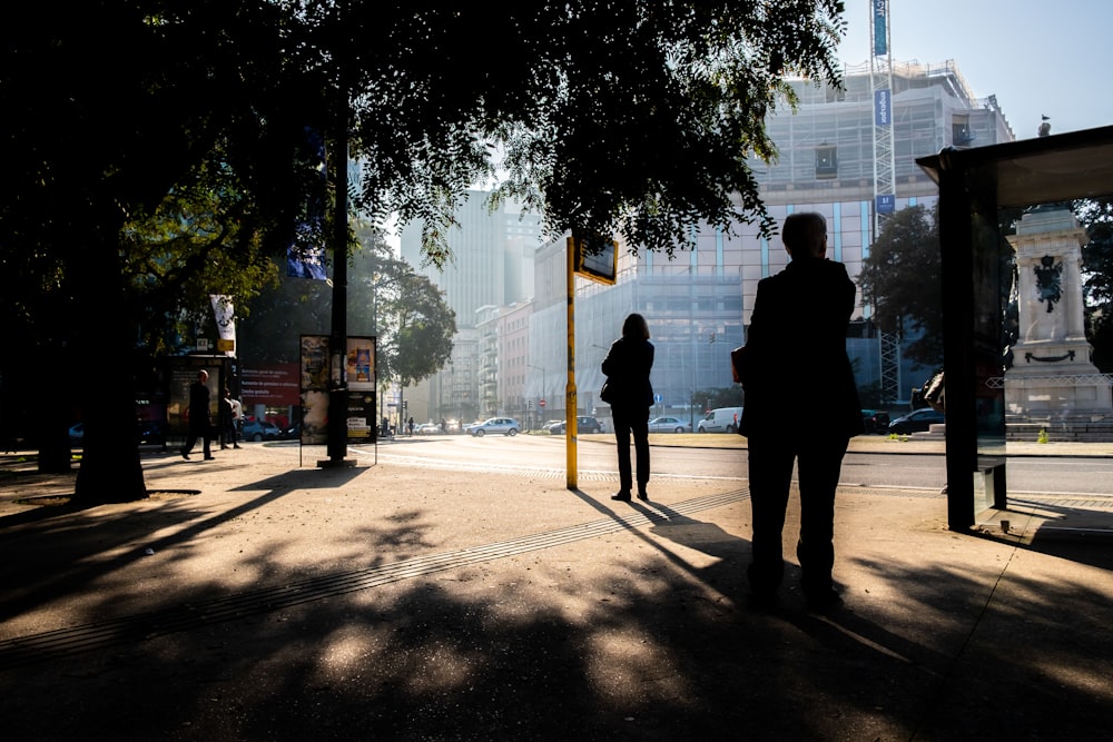 man in black jacket walking on sidewalk during daytime