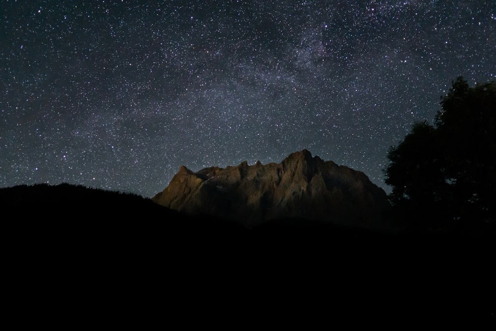 black and white mountain under starry night