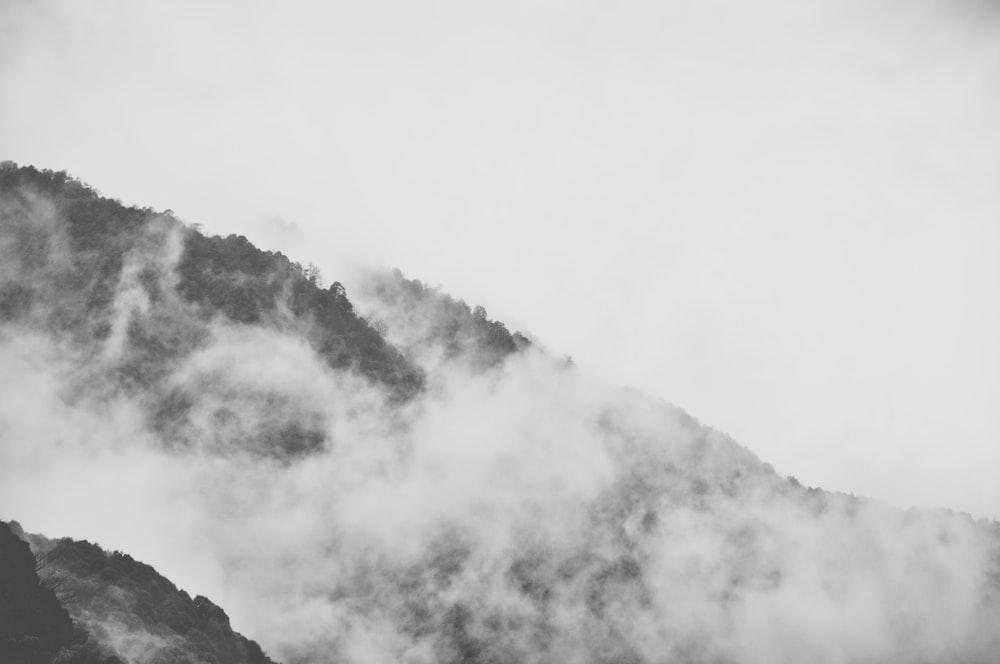 grayscale photo of mountain covered with clouds