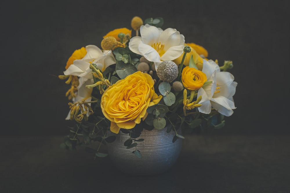 yellow and white flowers in blue ceramic vase