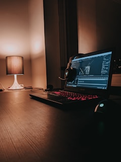 black laptop computer turned on beside white desk lamp