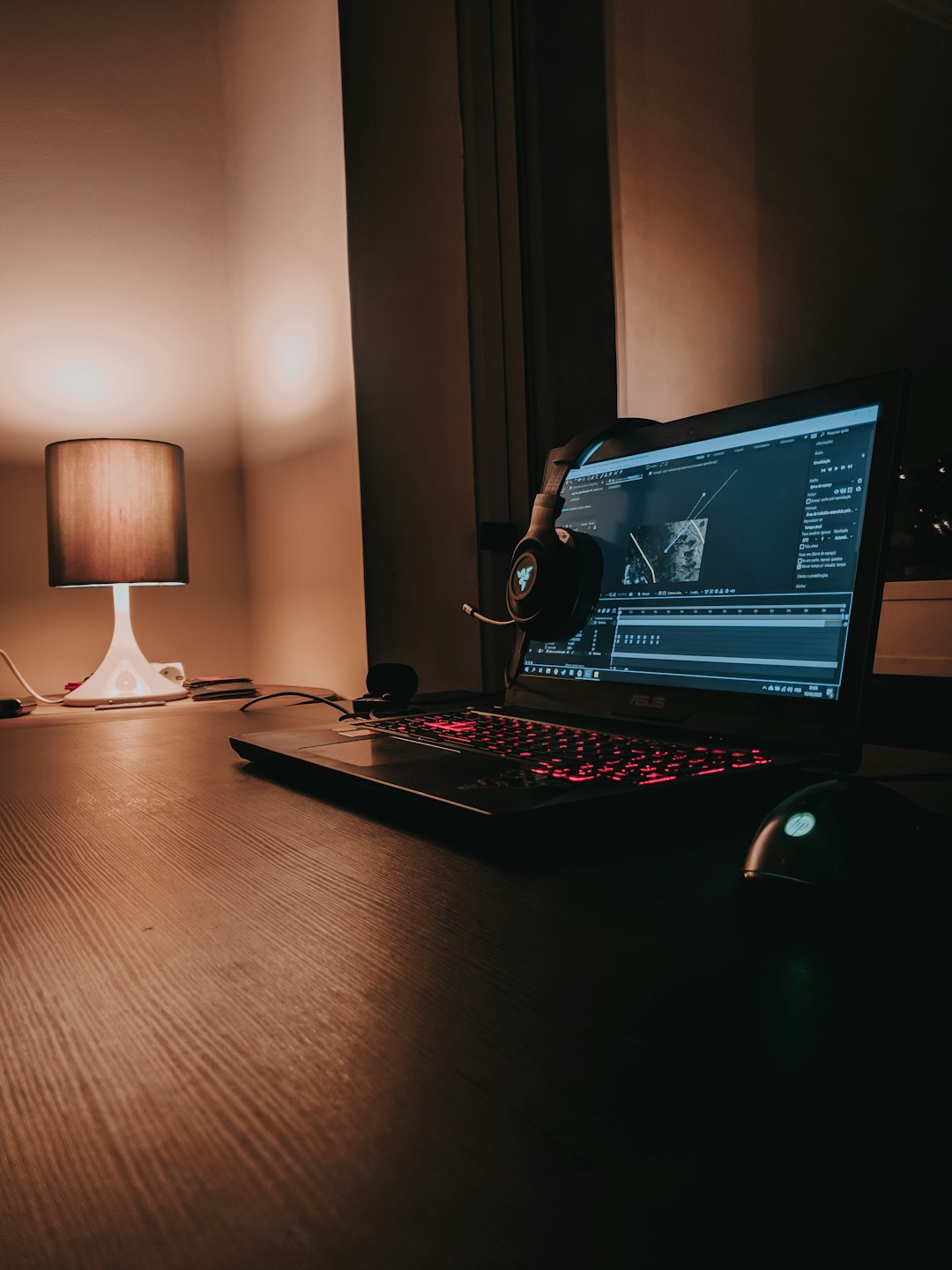 black laptop computer turned on beside white desk lamp