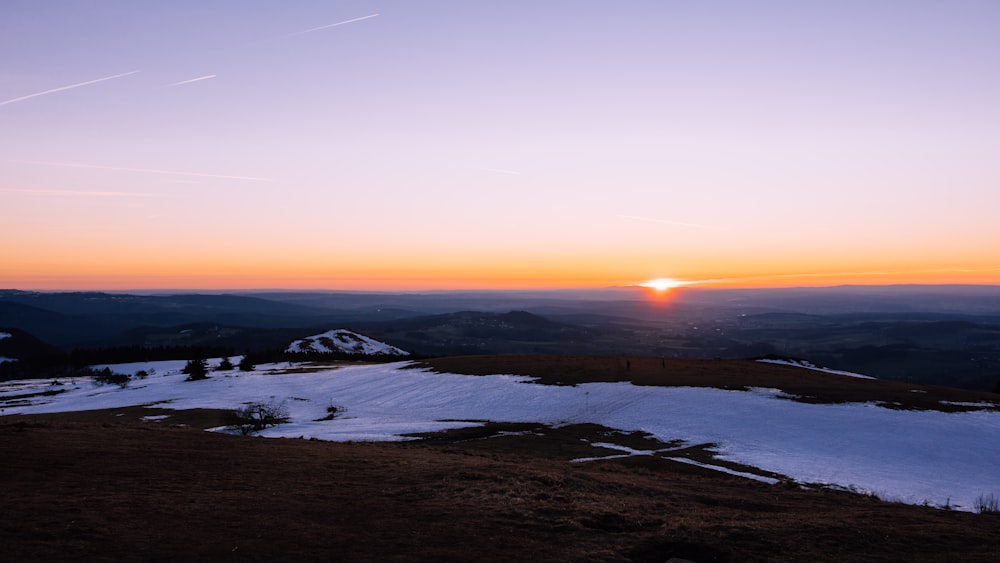 snow covered field during sunset