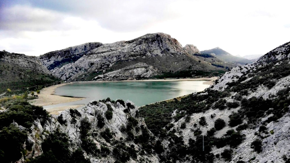 lake in the middle of mountains during daytime