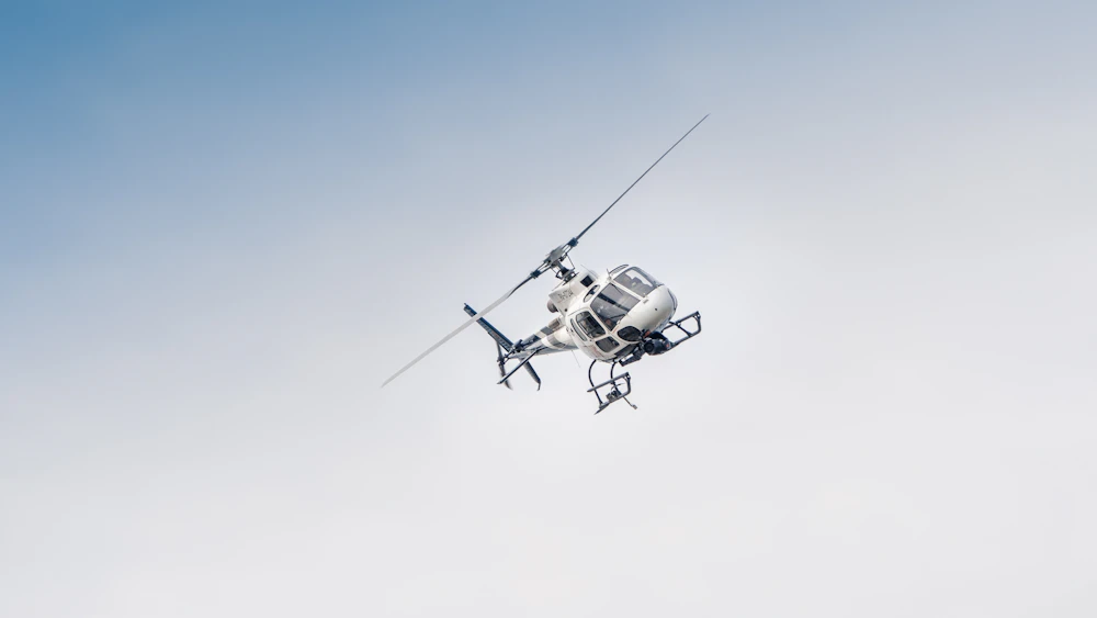 white and black drone flying under blue sky during daytime
