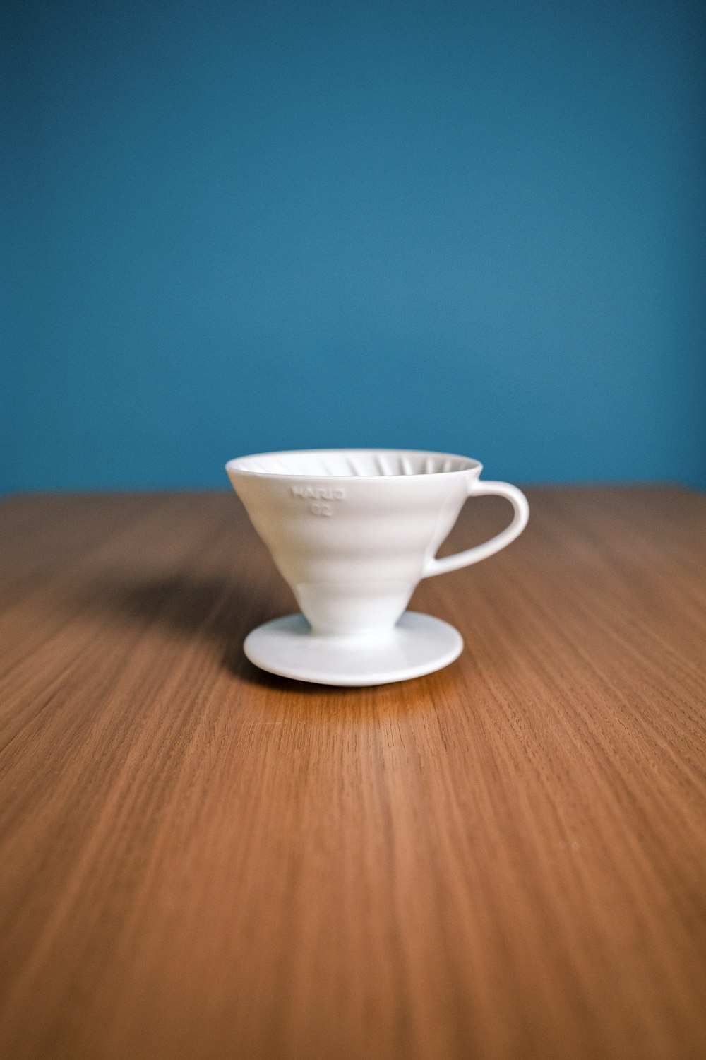 Tasse à thé en céramique blanche sur soucoupe blanche sur table en bois brun